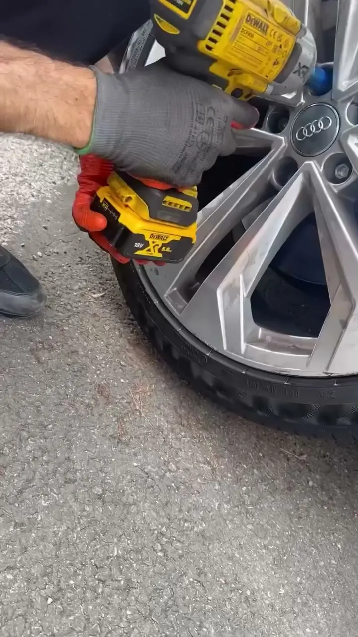 Technicien intervenant sur une roue avec une clé à chocs